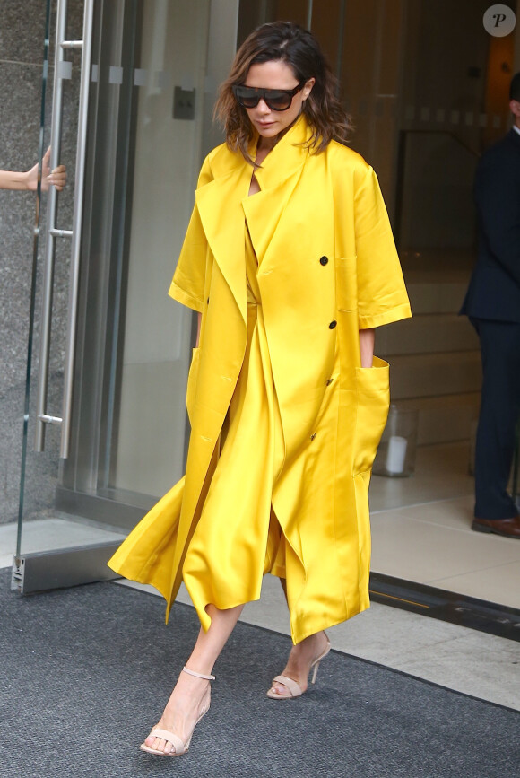 Exclusif - Victoria Beckham quitte un building de New York vêtue d'un ensemble jaune flashy le 23 juin 2016.