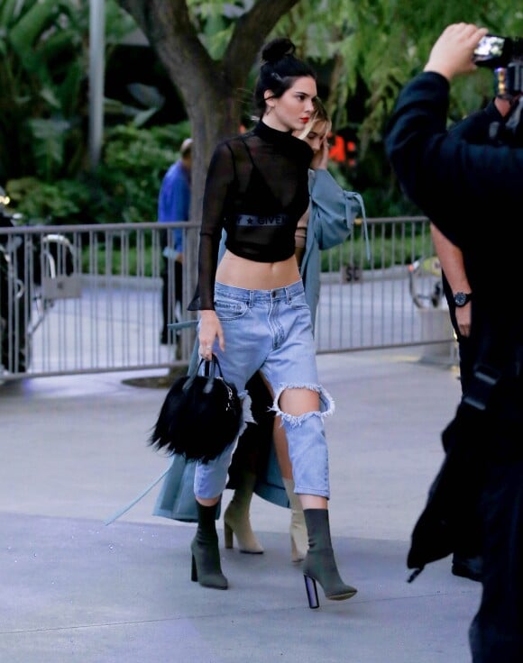 Kendall Jenner arrive au Staples Center à Los Angeles, habillée d'un crop top en mesh noir, d'une brassière Givenchy, d'un jean One Teaspoon et de chaussures YEEZY (collection SEASON 2). Le top model porte également un sac Givenchy en cuir et poil de chèvre. Le 6 août 2016.