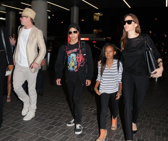 Brad Pitt et Angelina Jolie prennent un avion avec leurs enfants Maddox et Zahara à l'aéroport de LAX à Los Angeles. Brad Pitt porte un T-shirt avec un dessin fait à la main le représentant avec Angelina (fait par leur fille Vivienne). Le 6 juin 2014