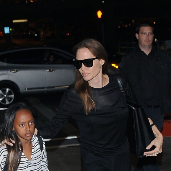 Brad Pitt et Angelina Jolie prennent un avion avec leurs enfants Maddox et Zahara à l'aéroport de LAX à Los Angeles. Brad Pitt porte un T-shirt avec un dessin fait à la main le représentant avec Angélina (fait par leur fille Vivienne). Le 6 juin 2014