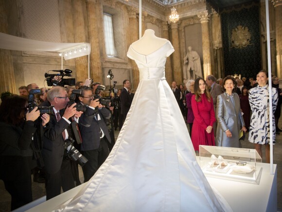 La princesse Sofia, la reine Silvia et la princesse Victoria de Suède devant la robe de mariée de cette dernière le 17 octobre 2016 au palais royal Drottningholm à Stockholm pour inaugurer l'exposition des robes de mariée royales.
