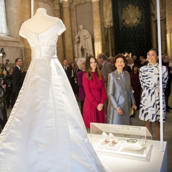 La princesse Sofia, la reine Silvia et la princesse Victoria de Suède devant la robe de mariée de cette dernière le 17 octobre 2016 au palais royal Drottningholm à Stockholm pour inaugurer l'exposition des robes de mariée royales.