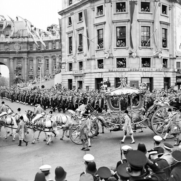 La reine Elizabeth II, avec son époux le duc d'Edimbourg, lors de la procession entre le palais de Buckingham et l'abbaye de Westminster le jour de son couronnement, le 2 juin 1953, à Londres.