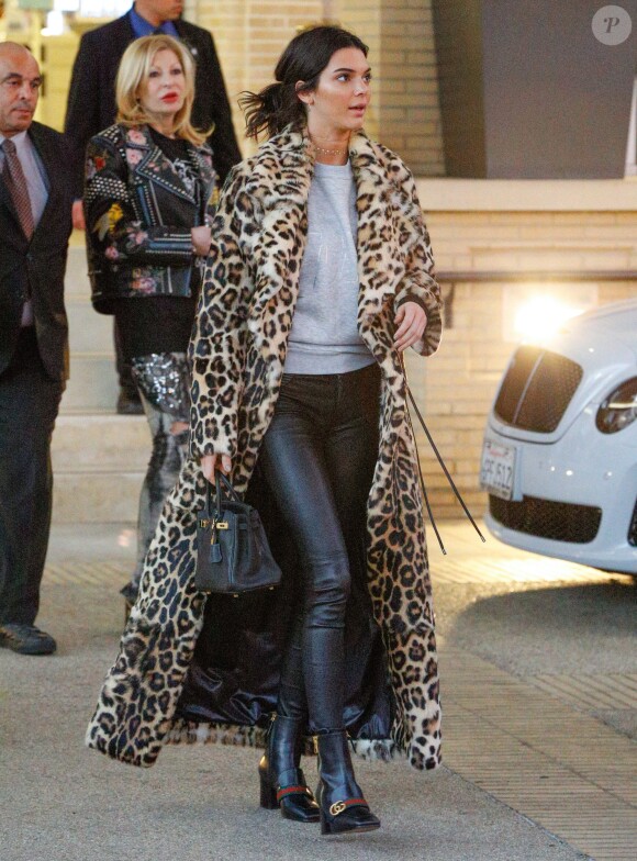 Kendall Jenner quitte le Barney's New York à Beverly Hills, habillée d'un manteau léopard Plein Sud (collection hiver 2016), d'un pull en coton gris, d'un pantalon en cuir RtA et de chaussures Gucci. Le mannequin tient un sac Hermès. Le 7 décembre 2016.