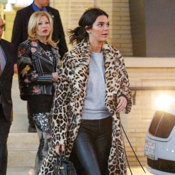 Kendall Jenner quitte le Barney's New York à Beverly Hills, habillée d'un manteau léopard Plein Sud (collection hiver 2016), d'un pull en coton gris, d'un pantalon en cuir RtA et de chaussures Gucci. Le mannequin tient un sac Hermès. Le 7 décembre 2016.