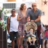 Exclusif - Eric Judor et sa compagne font une pause tendresse dans la rue à Saint-Tropez lors d'une balade avec leur fils le 17 août 2016.