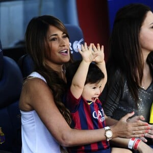 Antonella Roccuzzo et leur son thiago dans le stade du FC Barcelone avant le coup d'envoi à Barcelone en Espagne le 3 mai 2014.