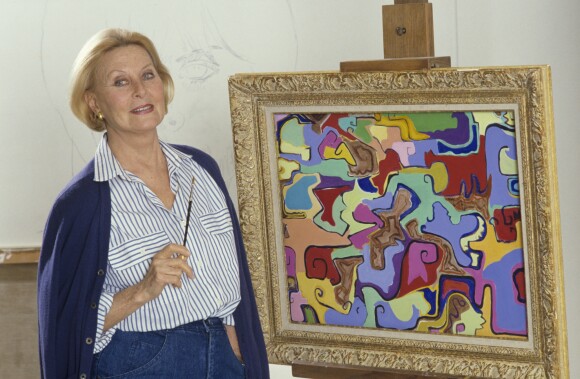 Archives - En France, à Neuilly-sur-Seine, Michèle Morgan chez elle, posant devant un de ses tableaux en novembre 1987.