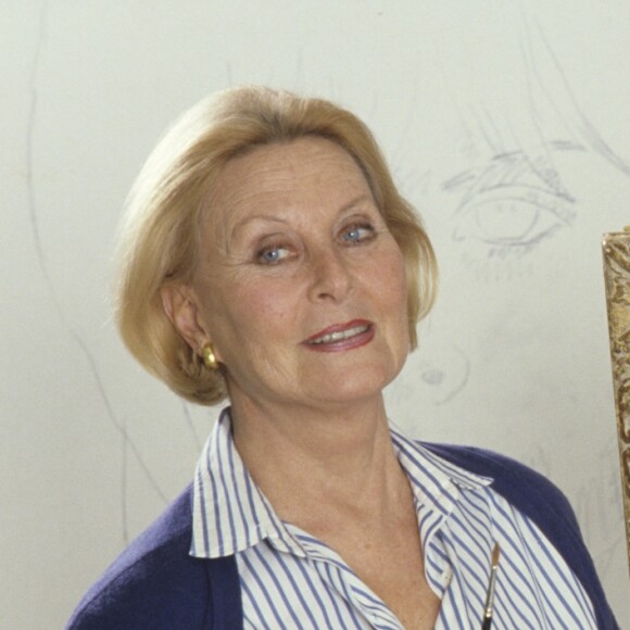 Archives - En France, à Neuilly-sur-Seine, Michèle Morgan chez elle, posant devant un de ses tableaux en novembre 1987.