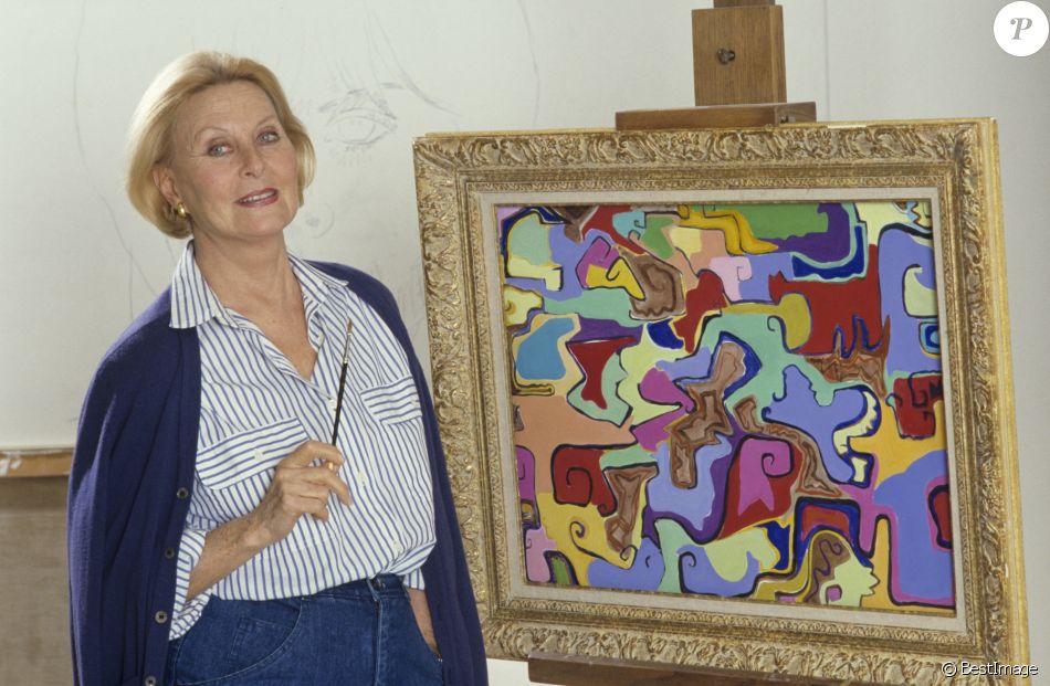 Archives - En France, à Neuilly-sur-Seine, Michèle Morgan chez elle, posant devant un de ses tableaux en novembre 1987.