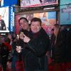 Exclusif - Les Chevaliers du Fiel dans les rues de New York. Le couple d'humoristes, Éric Carrière et Francis Ginibre, déguste un hot-dog devant sa photo sur les écrans vidéos gigantesques de Times Square. New York, le 14 décembre 2016 © Morgan Dessales / Bestimage