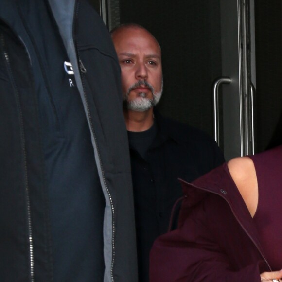 Kim Kardashian habillée de la tête aux pieds en bordeaux avec un haut très transparent à la sortie d'un immeuble à New York, le 15 février 2017.