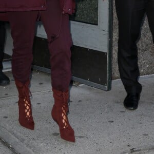 Kim Kardashian habillée de la tête aux pieds en bordeaux avec un haut très transparent à la sortie d'un immeuble à New York, le 15 février 2017.