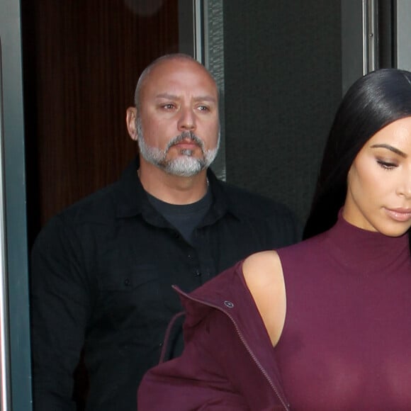 Kim Kardashian habillée de la tête aux pieds en bordeaux avec un haut très transparent à la sortie d'un immeuble à New York, le 15 février 2017.