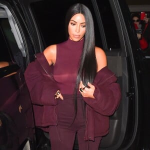 Kim Kardashian habillée de la tête aux pieds en bordeaux avec un haut très transparent à la sortie d'un immeuble à New York, le 15 février 2017.