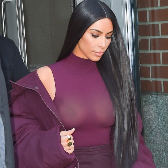 Kim Kardashian habillée de la tête aux pieds en bordeaux avec un haut très transparent à la sortie d'un immeuble à New York, le 15 février 2017.