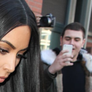 Kim Kardashian habillée de la tête aux pieds en bordeaux avec un haut très transparent à la sortie d'un immeuble à New York, le 15 février 2017.