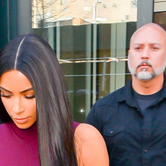 Kim Kardashian habillée de la tête aux pieds en bordeaux avec un haut très transparent à la sortie d'un immeuble à New York, le 15 février 2017.
