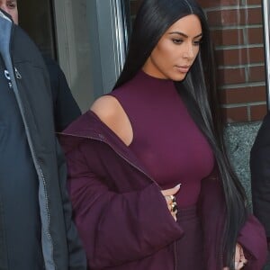 Kim Kardashian habillée de la tête aux pieds en bordeaux avec un haut très transparent à la sortie d'un immeuble à New York, le 15 février 2017.