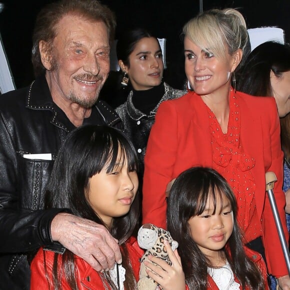 Johnny Hallyday, sa femme Laeticia (en béquilles) et leurs filles Jade et Joy au vernissage de l'exposition du photographe Mathieu Cesar à Los Angeles, le 21 février 2017.