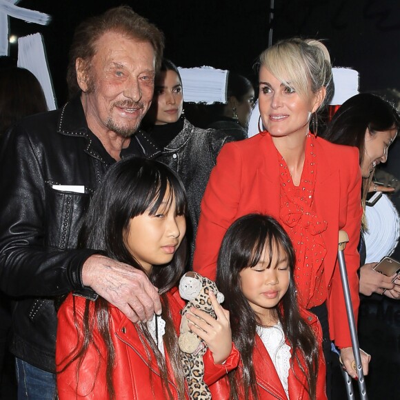 Johnny Hallyday, sa femme Laeticia (en béquilles) et leurs filles Jade et Joy au vernissage de l'exposition du photographe Mathieu Cesar à Los Angeles. Le 21 février 2017