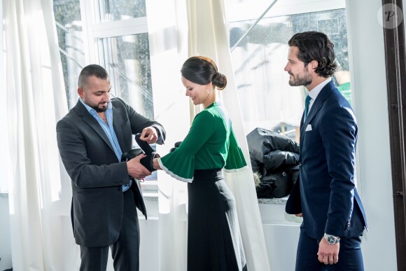 La princesse Sofia de Suède, habillée d'un pull COS vert en clin d'oeil à la Saint-Patrick, enfile des gants de boxe sous le regard de son mari le prince Carl Philip lors de l'inauguration d'un nouveau centre de loisirs pour les jeunes défavorisés à Husby, dans la banlieue de Stockholm, le 17 mars 2017.
