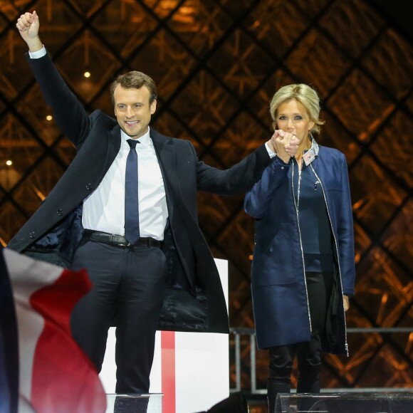 Emmanuel Macron, élu président de la république, et sa femme Brigitte Macron (Trogneux), saluent les militants devant la pyramide au musée du Louvre à Paris, après sa victoire lors du deuxième tour de l'élection présidentielle. Le 7 mai 2017.