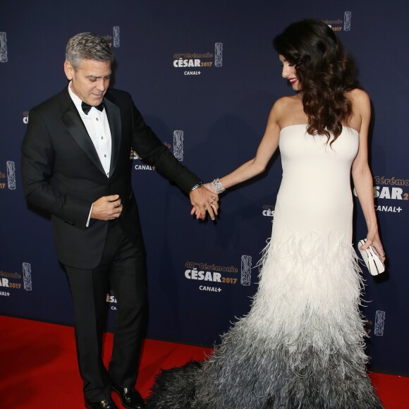 George Clooney (montre Omega) et sa femme Amal Alamuddin Clooney, enceinte et vêtue d'une robe Haute Couture Atelier Versace, assistent à la 42e cérémonie des César à la Salle Pleyel. Paris, le 24 février 2017. © Olivier Borde / Dominique Jacovides / Bestimage