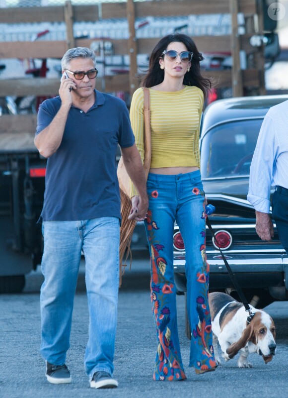 Amal Clooney, vêtue d'un pull Pepa Pombo (pré-collection automne 2016), d'un jean évasé alice + olivia et portant un sac à franges TALA by Tala Alamuddin, et son mari George Clooney sur le tournage de 'Suburbicon' à Los Angeles, Californie, le 20 octobre 2016.