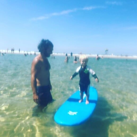 Bixente, le fils de Natasha St-Pier, s'essaye au surf à la plage, sous le regard attendri de son père Grégory Quillacq.