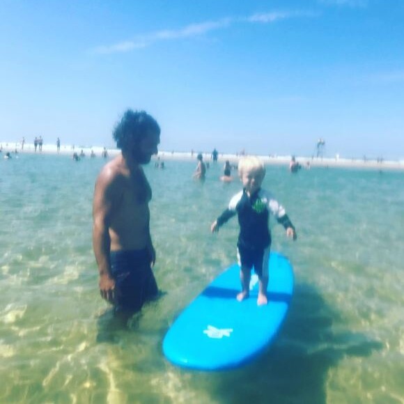 Bixente, le fils de Natasha St-Pier, s'essaye au surf à la plage, sous le regard attendri de son père Grégory Quillacq.
