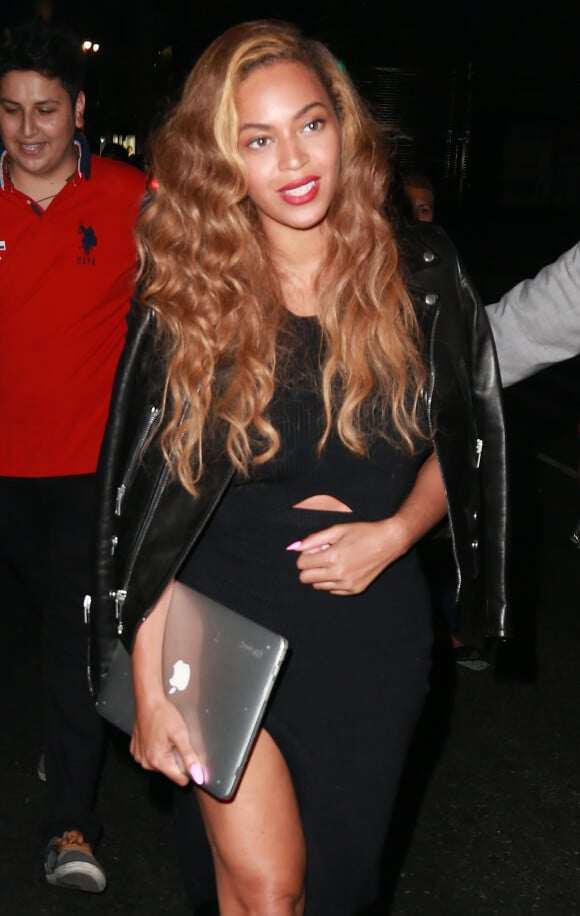 Beyonce Knowles, un MacBook Apple à la main, lors d'une sortie de nuit à New York, le 30 juin 2015.
