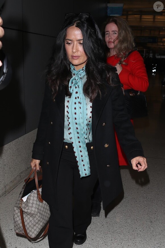 Salma Hayek arrive à l'aéroport de LAX à Los Angeles. Elle porte un sac Gucci. Le 16 novembre 2017