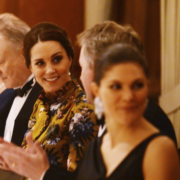 La duchesse Catherine de Cambridge, enceinte et en Erdem, lors d'un dîner à l'ambassade de Grande-Bretagne à Stockholm le 30 janvier 2018, avec à sa droite l'acteur Stellan Skarsgard et en discussion avec l'ambassadeur David Cairns.
