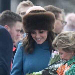 Kate Middleton regarde un vêtement offert pour ses enfants avec la reine Sonja de Norvège. La duchesse Catherine de Cambridge, enceinte et couverte d'un manteau Catherine Walker, et le prince William ont visité le 1er février 2018 le parc de sculptures Princesse Ingrid Alexandra dans les jardins du palais royal, en compagnie de la reine Sonja de Norvège, du prince héritier Haakon, de la princesse Mette-Marit et de leur fille la princesse Ingrid Alexandra, dans le cadre de leur visite officielle en Scandinavie.