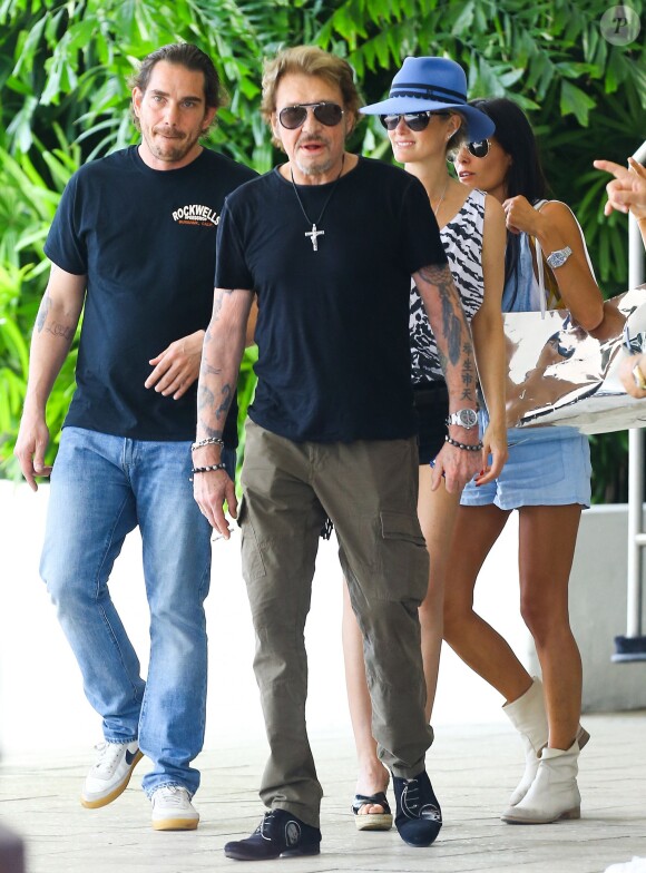 Johnny Hallyday et sa femme Laeticia quittent leur hôtel en compagnie de Sébastien Farran et du père de Laeticia, André Boudou à Miami, le 12 mai 2014.