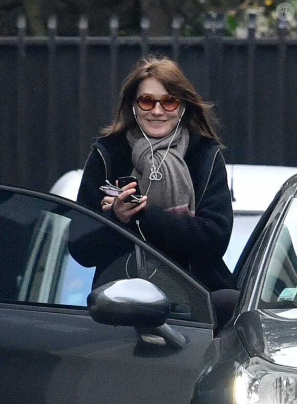 Semi-exclusif - Carla Bruni-Sarkozy quitte son domicile de Neuilly-sur-Seine très souriante le 23 mars 2018.