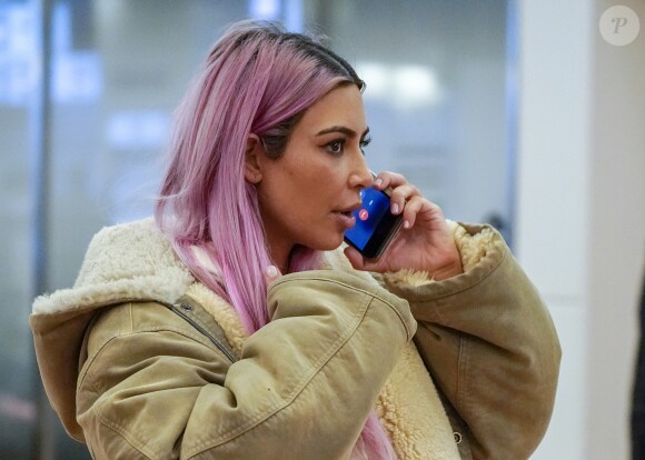 Kim Kardashian, nouvelle chevelure rose, téléphone à son arrivée à l'aéroport Hadena de Tokyo le 26 février 2018.
