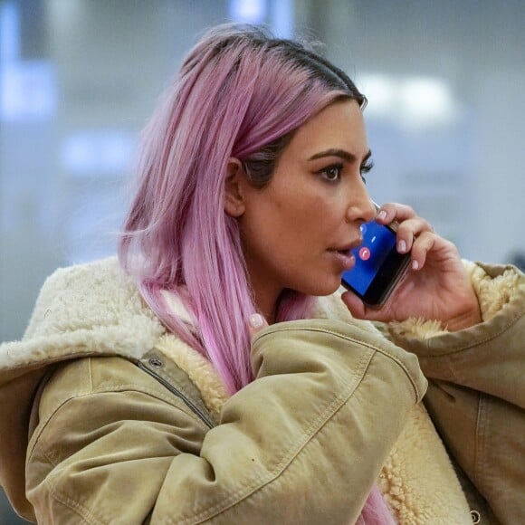 Kim Kardashian, nouvelle chevelure rose, téléphone à son arrivée à l'aéroport Hadena de Tokyo le 26 février 2018.