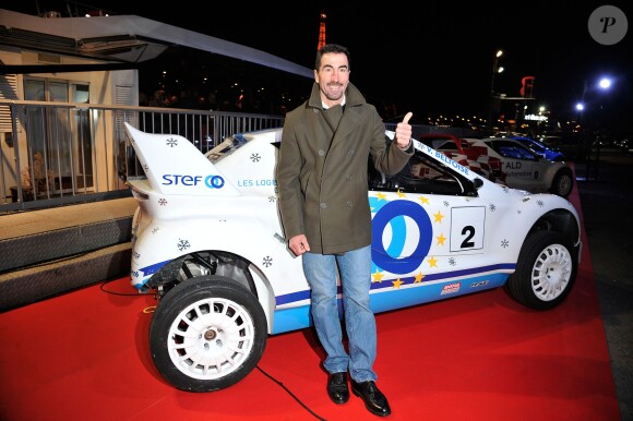 Luc Alphand pose devant sa voiture lors de la conférence de presse de la 25ème édition du Trophée Andros à Paris le 27 novembre 2013.