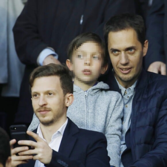 Grand Corps Malade (Fabien Marsaud) et son fils Yannis dans les tribunes du Parc des Princes lors du match de Ligue 1 PSG - Rennes à Paris, le 12 mai 2018, à l'issue duquel le Paris Saint-Germain a fêté son titre de champion de France.