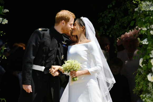 Le prince Harry et Meghan Markle (en robe de mariée Givenchy), duc et duchesse de Sussex, échangeant un baiser à la sortie de chapelle St. George au château de Windsor après leur mariage le 19 mai 2018.