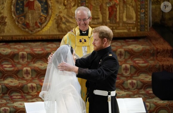 Le prince Harry (qui ôte ici le voile de Meghan) et Meghan Markle, duc et duchesse de Sussex, ont célébré leur mariage le 19 mai 2018 en la chapelle St George à Windsor. Une cérémonie marquée notamment par leur émouvante complicité amoureuse, qui sautait aux yeux...