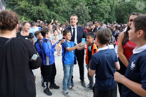 Le président français Emmanuel Macron pose avec les enfants d'associations sportives - Le président de la République Française E. Macron et la Première dame B. Macron, accueillent les joueurs de l'équipe de France (Les Bleus) et son sélectionneur D. Deschamps, le président de la Fédération Française de Football N. Le Graët et des membres de la FFF, dans les jardins du Palais de l'Elysée à Paris, le 16 juillet 2018. L'équipe de France a été sacrée Championne du Monde 2018, pour la deuxième fois de son histoire, après sa victoire en finale face à la Croatie (4-2) © Sébastien Valiela/Bestimage