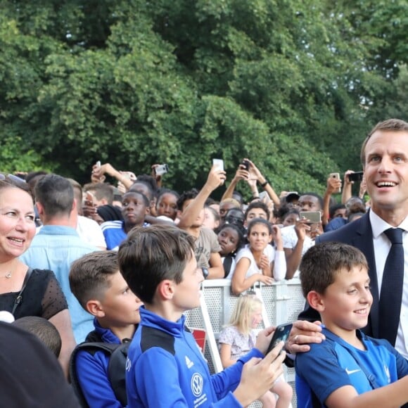 Le président français Emmanuel Macron pose avec les enfants d'associations sportives - Le président de la République Française E. Macron et la Première dame B. Macron, accueillent les joueurs de l'équipe de France (Les Bleus) et son sélectionneur D. Deschamps, le président de la Fédération Française de Football N. Le Graët et des membres de la FFF, dans les jardins du Palais de l'Elysée à Paris, le 16 juillet 2018. L'équipe de France a été sacrée Championne du Monde 2018, pour la deuxième fois de son histoire, après sa victoire en finale face à la Croatie (4-2) © Sébastien Valiela/Bestimage