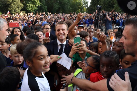 Le président français Emmanuel Macron pose avec les enfants d'associations sportives - Le président de la République Française E. Macron et la Première dame B. Macron, accueillent les joueurs de l'équipe de France (Les Bleus) et son sélectionneur D. Deschamps, le président de la Fédération Française de Football N. Le Graët et des membres de la FFF, dans les jardins du Palais de l'Elysée à Paris, le 16 juillet 2018. L'équipe de France a été sacrée Championne du Monde 2018, pour la deuxième fois de son histoire, après sa victoire en finale face à la Croatie (4-2) © Sébastien Valiela/Bestimage