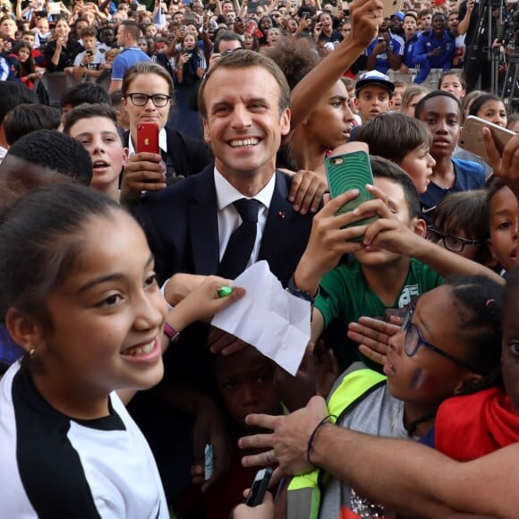 Le président français Emmanuel Macron pose avec les enfants d'associations sportives - Le président de la République Française E. Macron et la Première dame B. Macron, accueillent les joueurs de l'équipe de France (Les Bleus) et son sélectionneur D. Deschamps, le président de la Fédération Française de Football N. Le Graët et des membres de la FFF, dans les jardins du Palais de l'Elysée à Paris, le 16 juillet 2018. L'équipe de France a été sacrée Championne du Monde 2018, pour la deuxième fois de son histoire, après sa victoire en finale face à la Croatie (4-2) © Sébastien Valiela/Bestimage