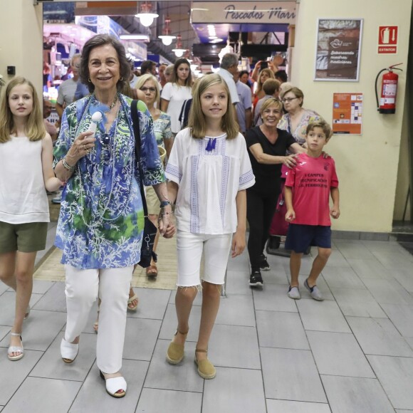 La reine Letizia d'Espagne, ses filles la princesse Leonor et l'infante Sofia, ainsi que la reine Sofia se sont promenées ensemble au marché couvert de l'Olivar à Palma de Majorque le 31 juillet 2018, près de quatre mois après le scandale de la messe de Pâques dans lequel elles avaient été impliquées.