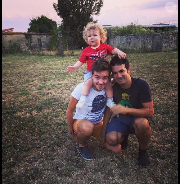 Alex Goude pose avec son mari Romain et leur fils Elliot. Instagram, août 2016