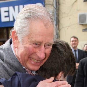 Le prince Charles, prince de Galles, prend dans ses bras Valentine Blacker, le fils de William Blacker, défenseur de l'environnement, pendant sa visite de la vieille ville à Bucarest, le 31 mars 2017.